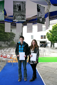Mateja in Žiga pod svojima fotografijama z osvojenim priznanjem in nagrado.